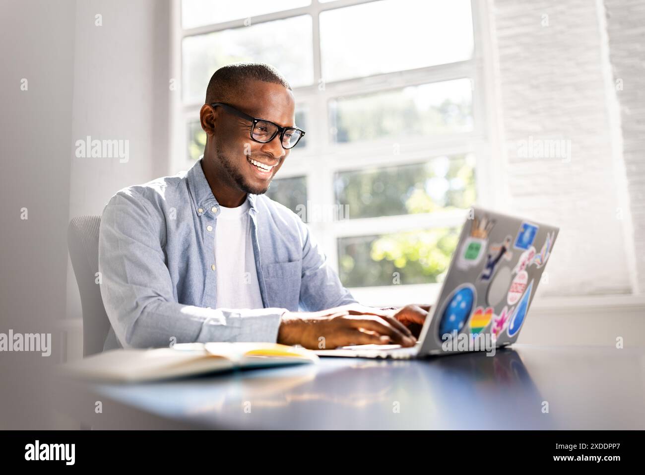 Digital Marketing Wizard: Un giovane designer che realizza prototipi di interfaccia utente su notebook in Chic Office Space Foto Stock