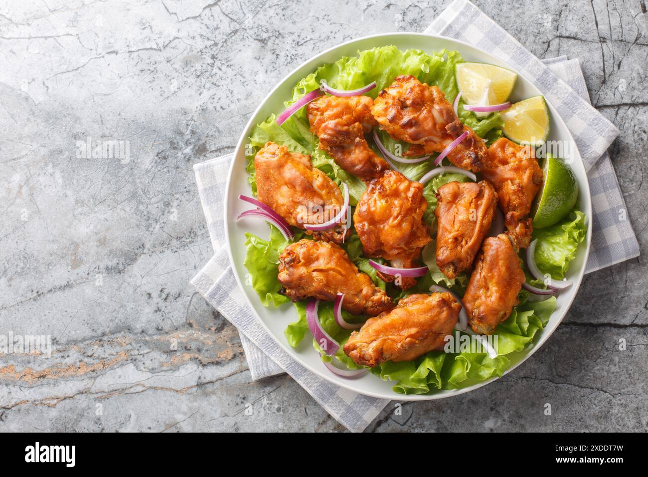 Il pollo fritto in stile asiatico viene marinato con pasta Tom Yam e poi fritto in profondità fino al primo piano perfetto sul piatto sul tavolo. Vista dall'alto orizzontale Foto Stock