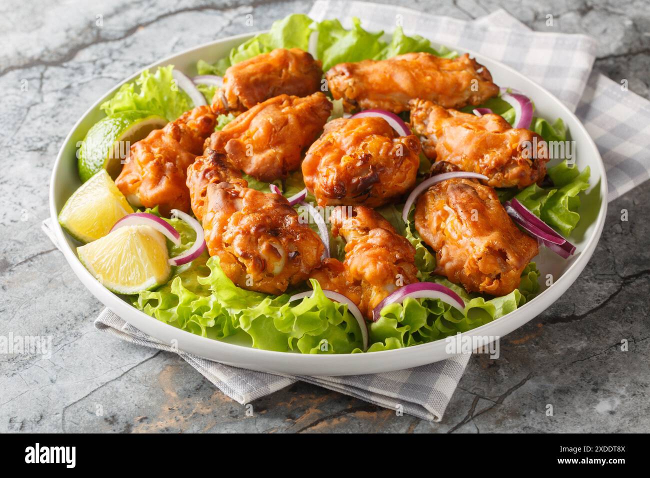 Il pollo fritto in stile asiatico viene marinato con pasta Tom Yam e poi fritto in profondità fino al primo piano perfetto sul piatto sul tavolo. Orizzontale Foto Stock