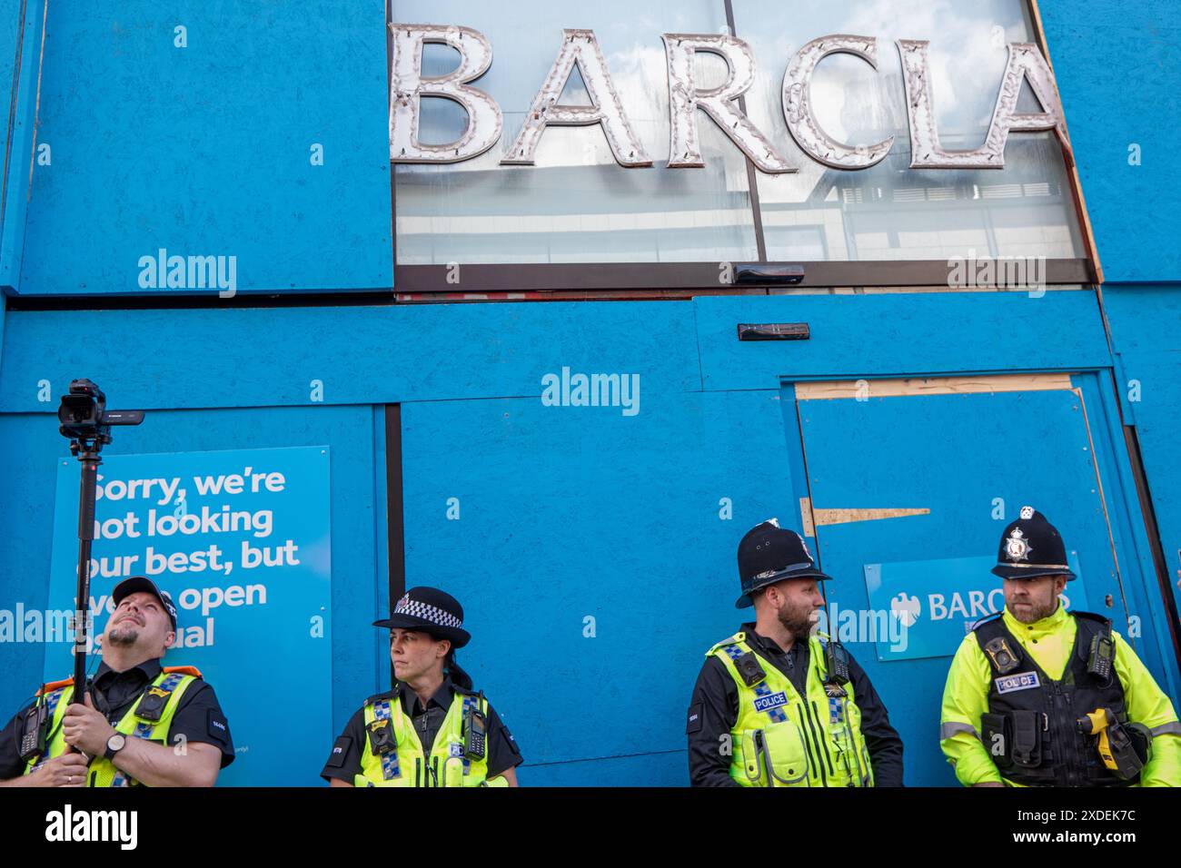 Manchester, Regno Unito. 22 giugno 2024. E' salito sulla Barclays Bank sorvegliata dalla polizia in Market Street. Proteste di guerra palestinesi a Gaza a Manchester nel Regno Unito. I manifestanti hanno marciato da Piazza San Pietro attraverso il centro della città. Gli striscioni includevano messaggi che chiedevano di fermare il genocidio di gaza da parte di Israele e di liberare la Palestina. I manifestanti includevano membri della comunità LGBGT che portavano striscioni che esprimevano il loro sostegno ai palestinesi. La Barclays Bank su Market Street rimane impressa da cartelli che si scusano. Manchester Regno Unito. Crediti: GaryRobertsphotography/Alamy Live News Foto Stock