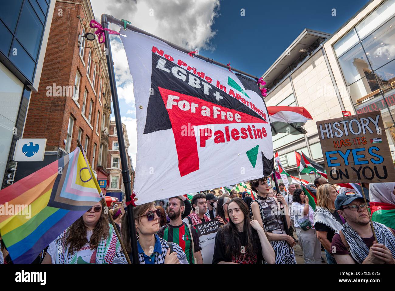 Manchester, Regno Unito. 22 giugno 2024. I membri della comunità LGBT+ mostrano sostegno alla Palestina. Proteste di guerra palestinesi a Gaza a Manchester nel Regno Unito. I manifestanti hanno marciato da Piazza San Pietro attraverso il centro della città. Gli striscioni includevano messaggi che chiedevano di fermare il genocidio di gaza da parte di Israele e di liberare la Palestina. I manifestanti includevano membri della comunità LGBGT che portavano striscioni che esprimevano il loro sostegno ai palestinesi. La Barclays Bank su Market Street rimane impressa da cartelli che si scusano. Manchester Regno Unito. Crediti: GaryRobertsphotography/Alamy Live News Foto Stock