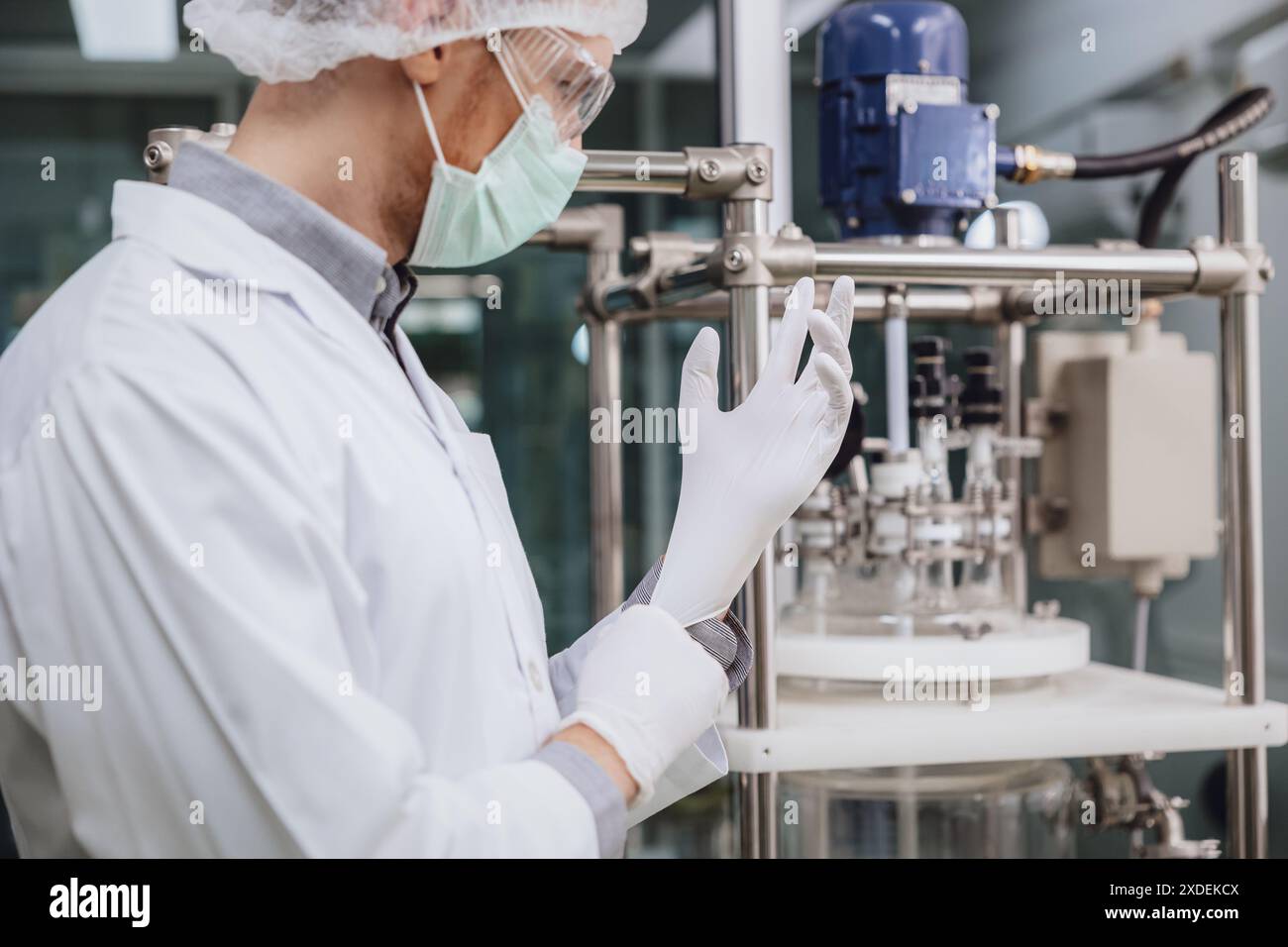 Personale scienziato che indossa guanti medici in lattice in laboratorio di scienza. Personale medico della fabbrica in camera bianca. Processi per impianti farmaceutici. Foto Stock