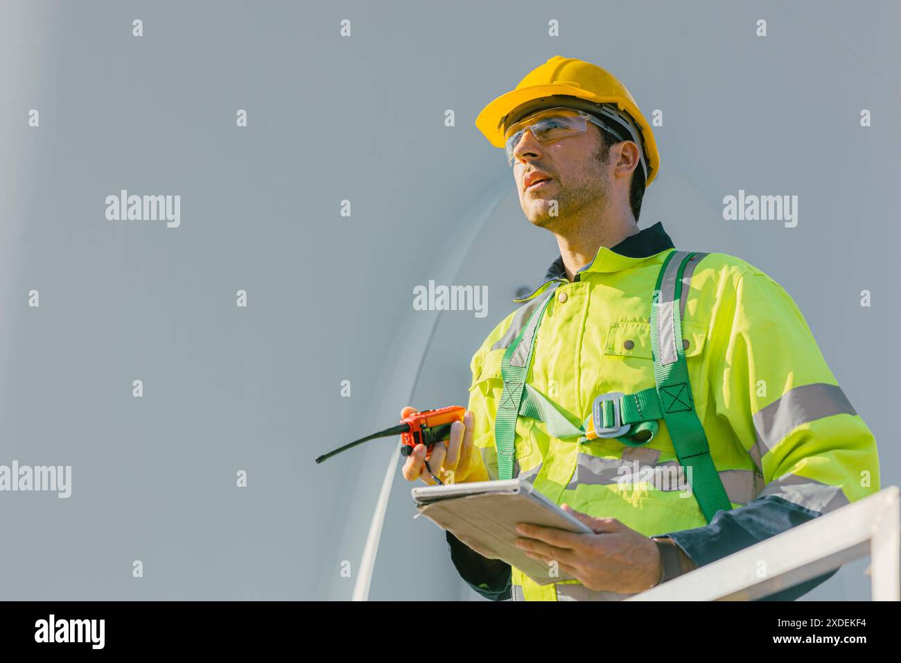 ingegnere professionista uomo che lavora all'aperto con sicurezza nelle turbine eoliche centrali elettriche a energia pulita background, lavoratori con energia rinnovabile tec Foto Stock