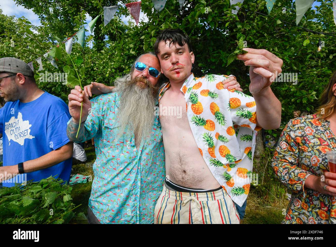 Waytown, Dorset, Regno Unito. 22 giugno 2024. I concorrenti osservati da una folla entusiasta partecipano all'annuale World Nettle Eating Championship presso la Dorset Nectar Cider Farm di Waytown nel Dorset. Lo scopo della competizione è quello di mangiare le foglie da molti gambi di ortica da due piedi il più possibile in 30 minuti, che vengono lavati via dal sidro. Crediti fotografici: Graham Hunt/Alamy Live News Foto Stock