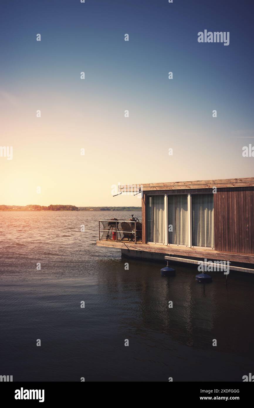 Una casa galleggiante su un lago al tramonto. Foto Stock
