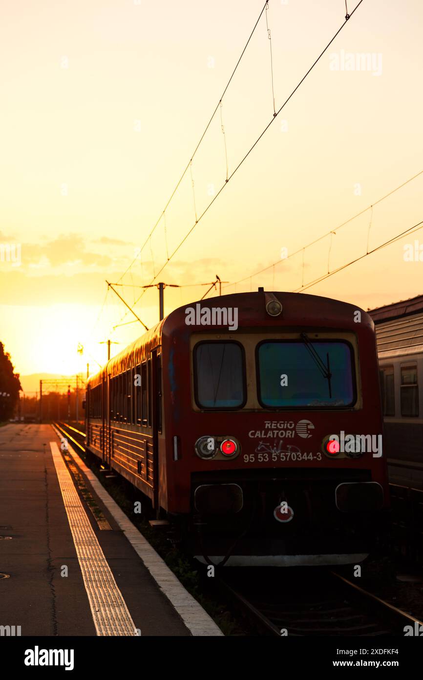 Brasov, Romania - 26 agosto 2022: Treno passeggeri al tramonto senza persone in piedi alla stazione ferroviaria di Brasov, gara Brasov. Ferrovie rumene. Foto Stock