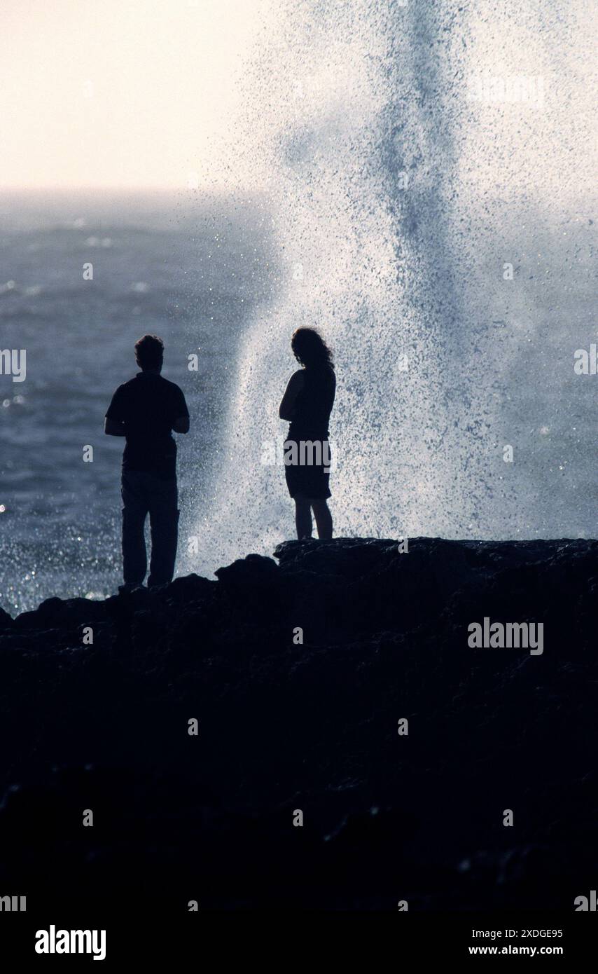 2 persone in piedi di fronte a un blowhole, Quobba, Australia Occidentale Foto Stock