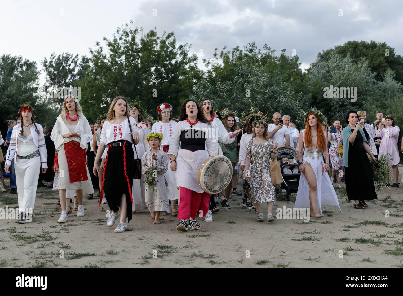 Un coro femminile bielorusso con partecipanti alla celebrazione si dirige verso il fiume per galleggiare corone nell'acqua durante Kupalle (notte di Kupala o notte di mezza estate) a Varsavia. Diverse centinaia di rappresentanti della diaspora bielorussa a Varsavia si sono riuniti per celebrare Kupalle (o notte di Kupala) sulla riva destra del fiume Vistola. Kupalle è una delle principali feste popolari in Bielorussia. Celebrata come Midsummer (notte di mezza estate), Kupalle è un evento tradizionale che segna la stagione estiva e si svolge il giorno o vicino alla data del solstizio d'estate. Dopo una significativa ondata di immigrazione politica f Foto Stock