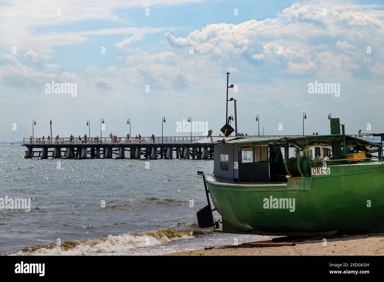 Barca da pesca sulla spiaggia in una mattinata di sole. Vista del molo. Golfo di Gdańsk, Gdynia Orłowo. Turismo in Europa, Polonia, Pomerania, Gdynia. Relaxatio Foto Stock