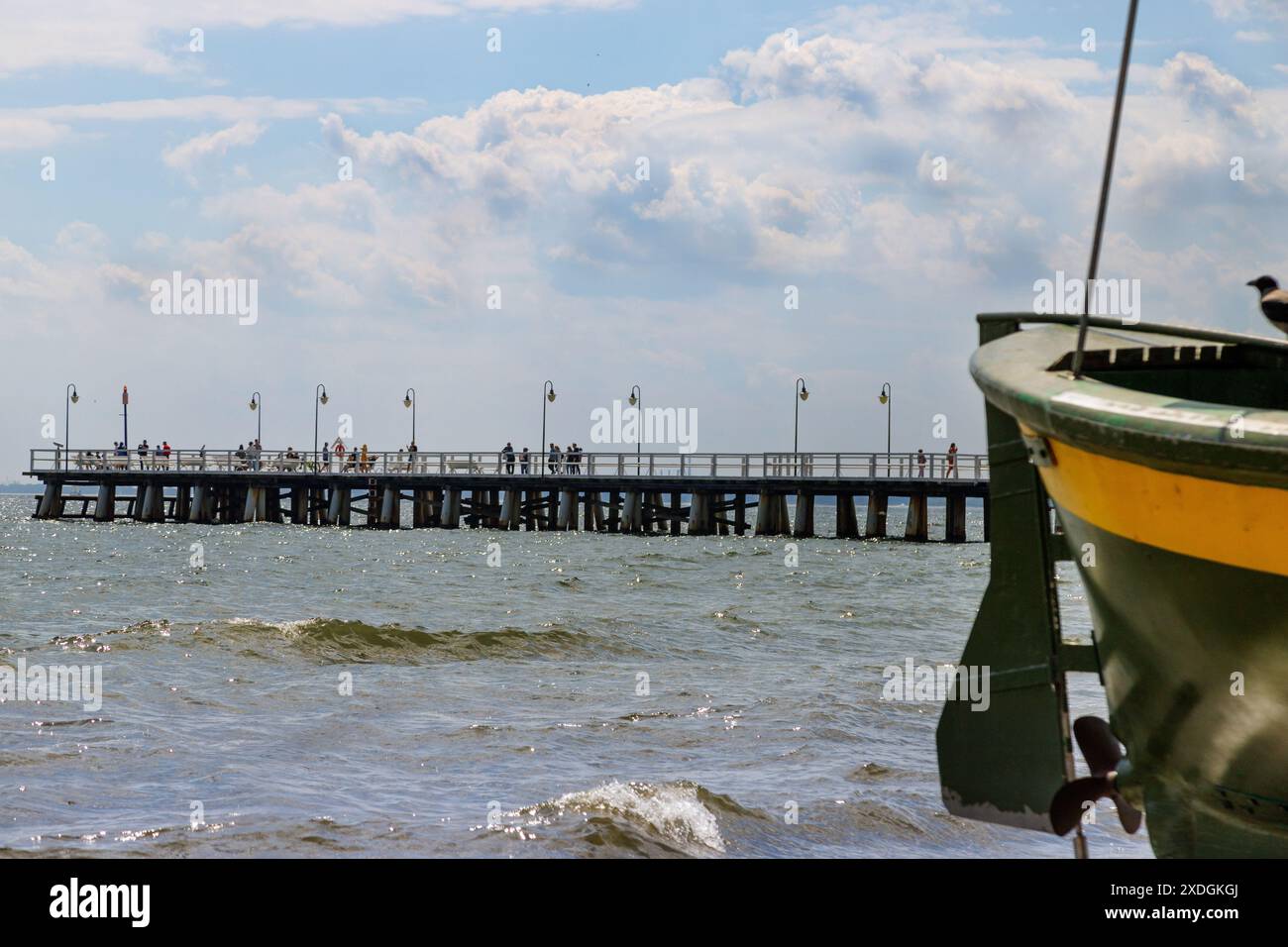 Barca da pesca sulla spiaggia in una mattinata di sole. Vista del molo. Golfo di Gdańsk, Gdynia Orłowo. Turismo in Europa, Polonia, Pomerania, Gdynia. Relaxatio Foto Stock