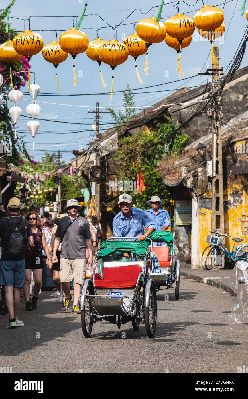 Vietnam taxi servizio triciclo turisti in bicicletta in giro per la città. Operaio vietnamita in sella a triciclo per i viaggiatori in servizio. Cyclo è mos Foto Stock