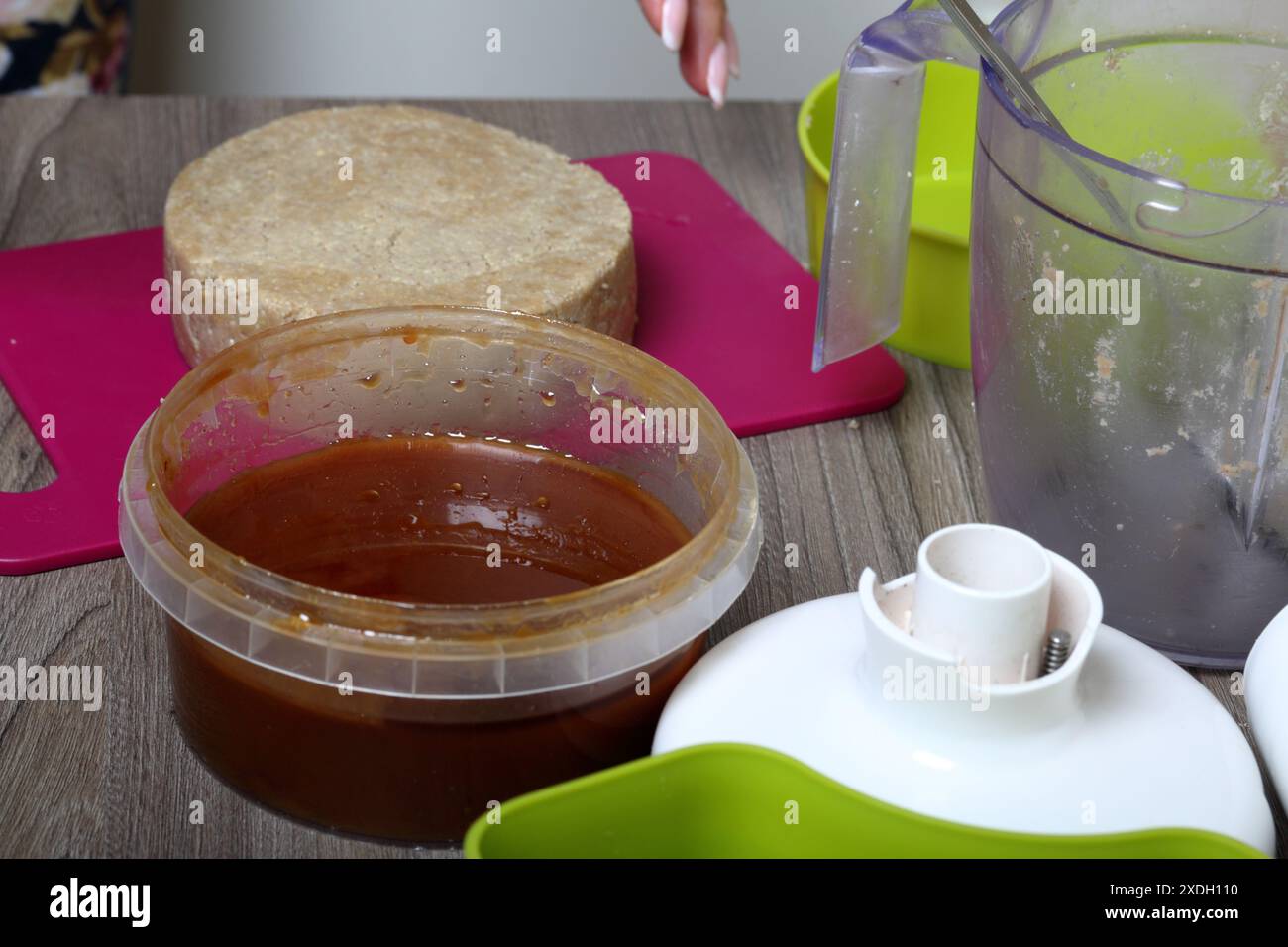 Halva di miele, arachidi e semi di girasole. Il prossimo miele nel contenitore. Ingredienti e strumenti per la preparazione dell'halva. Foto Stock