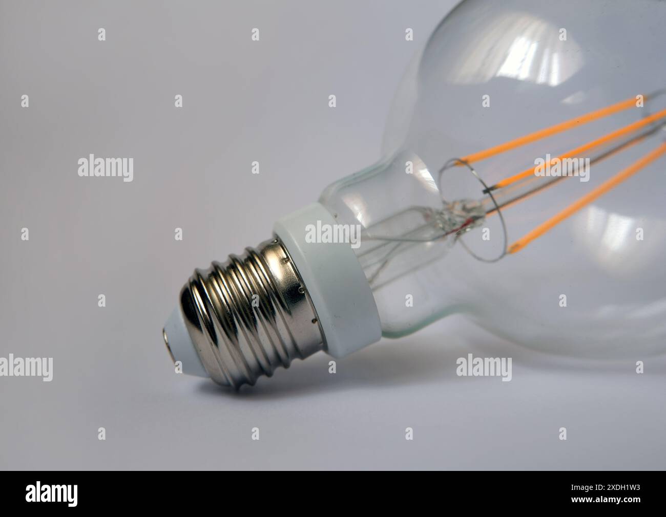 Lampadina. Lampadina LED a incandescenza. Immagine del concetto di energia e illuminazione. Focalizzato sulla baionetta della lampada. Foto Stock