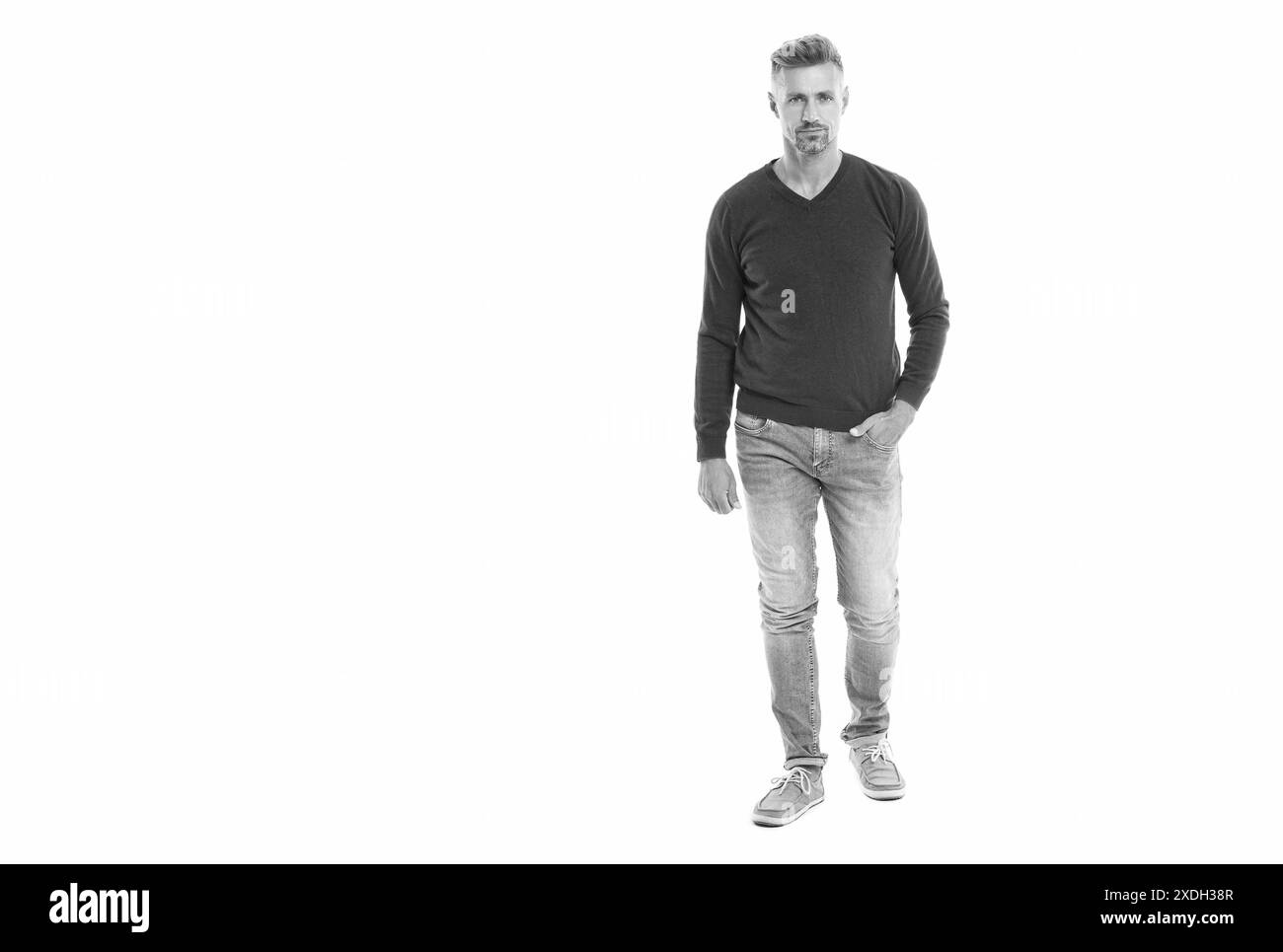 Un uomo caucasico che indossa un pullover, uno striscione. un uomo caucasico di 40 anni in studio. bell'uomo caucasico si trova in piedi. lunghezza completa di a. Foto Stock