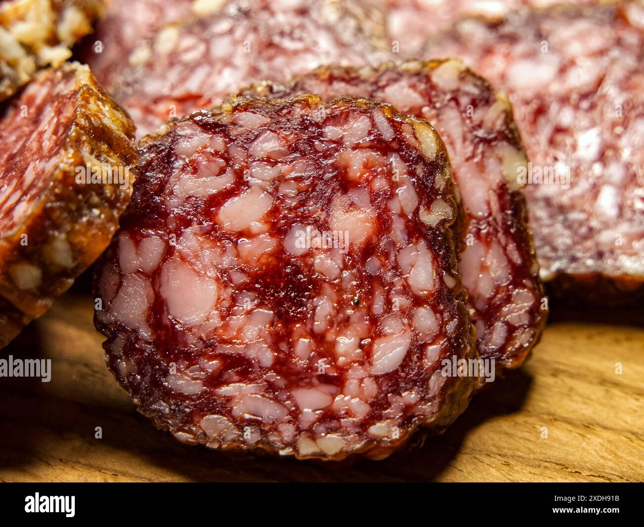 Presentazione dei salumi. Fette di salame su legno, ideali per l'educazione culinaria. Foto Stock