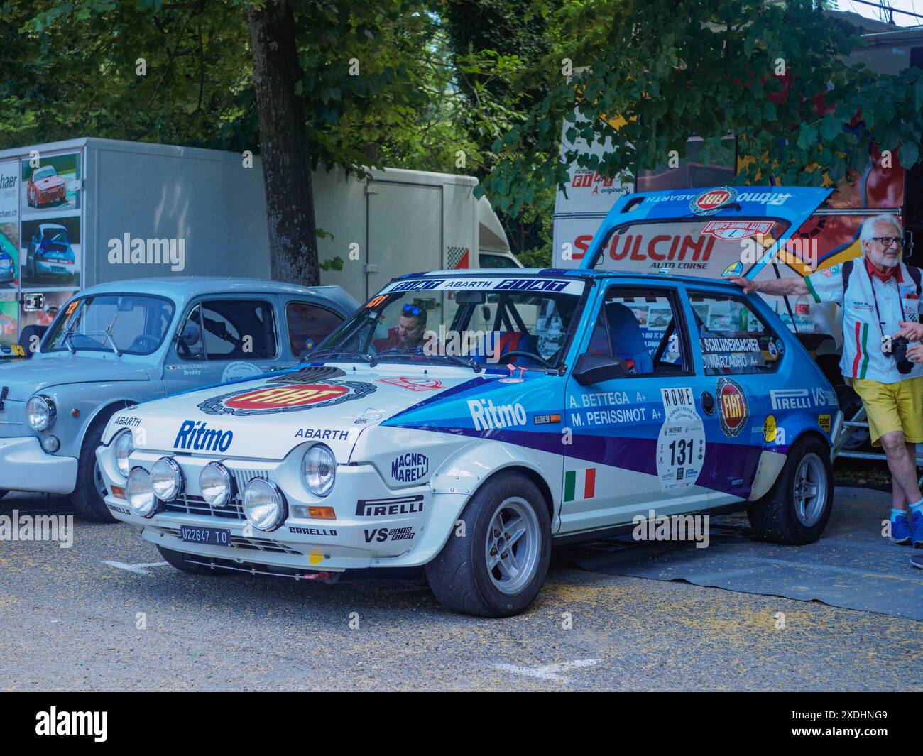 Castellarquato, Italia - 22 giugno 2024 evento bandiera d'Argento , pilota in piedi davanti al cofano aperto di una classica fiat ritmo abarth auto da rally a bianca e blu Foto Stock