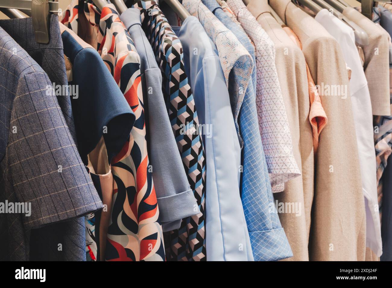 Una cremagliera di vestiti con una camicia blu dal design rosso e bianco Foto Stock