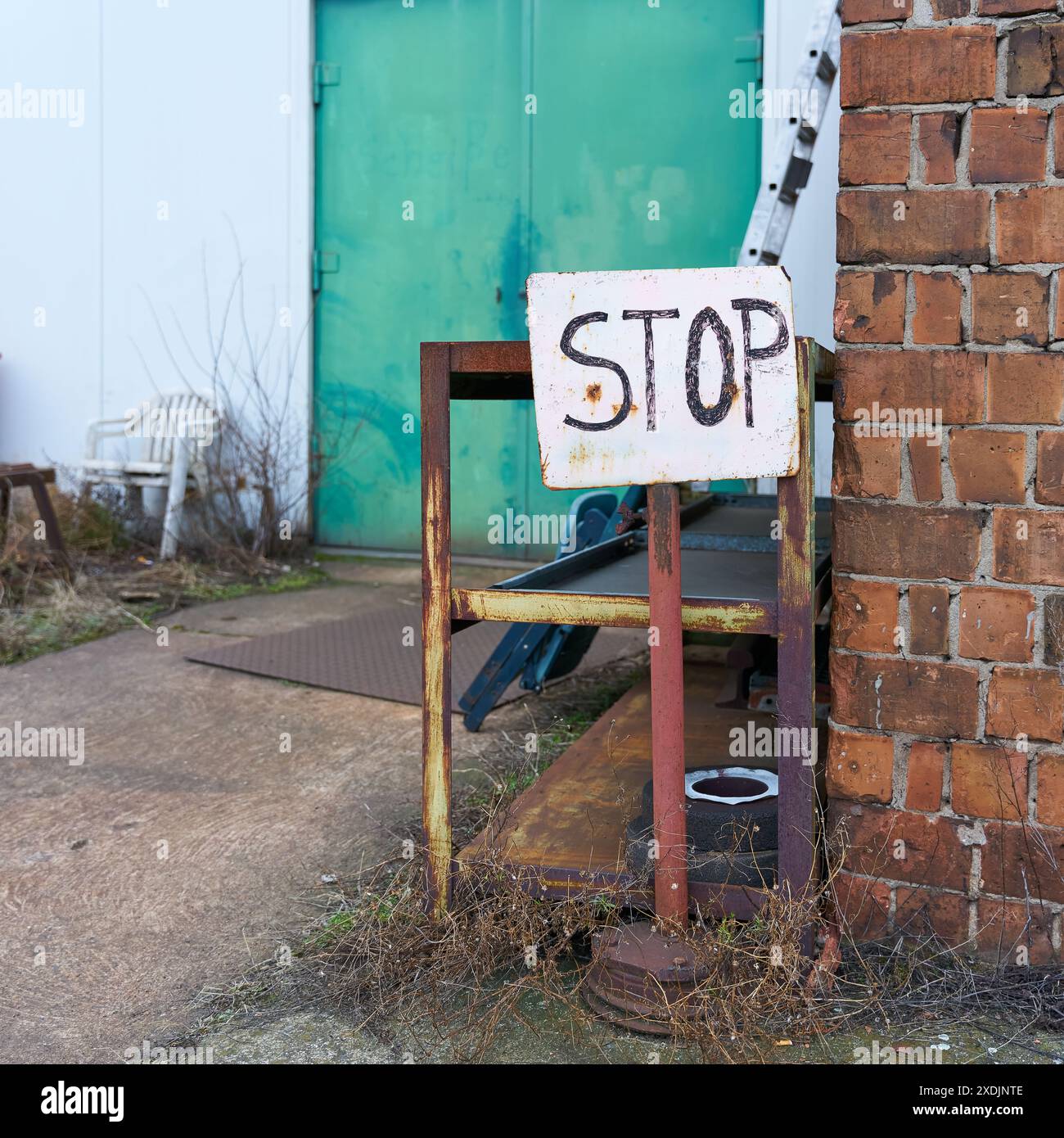 Firma con l'iscrizione Stop in un sito aziendale abbandonato alla periferia di Magdeburgo, in Germania Foto Stock