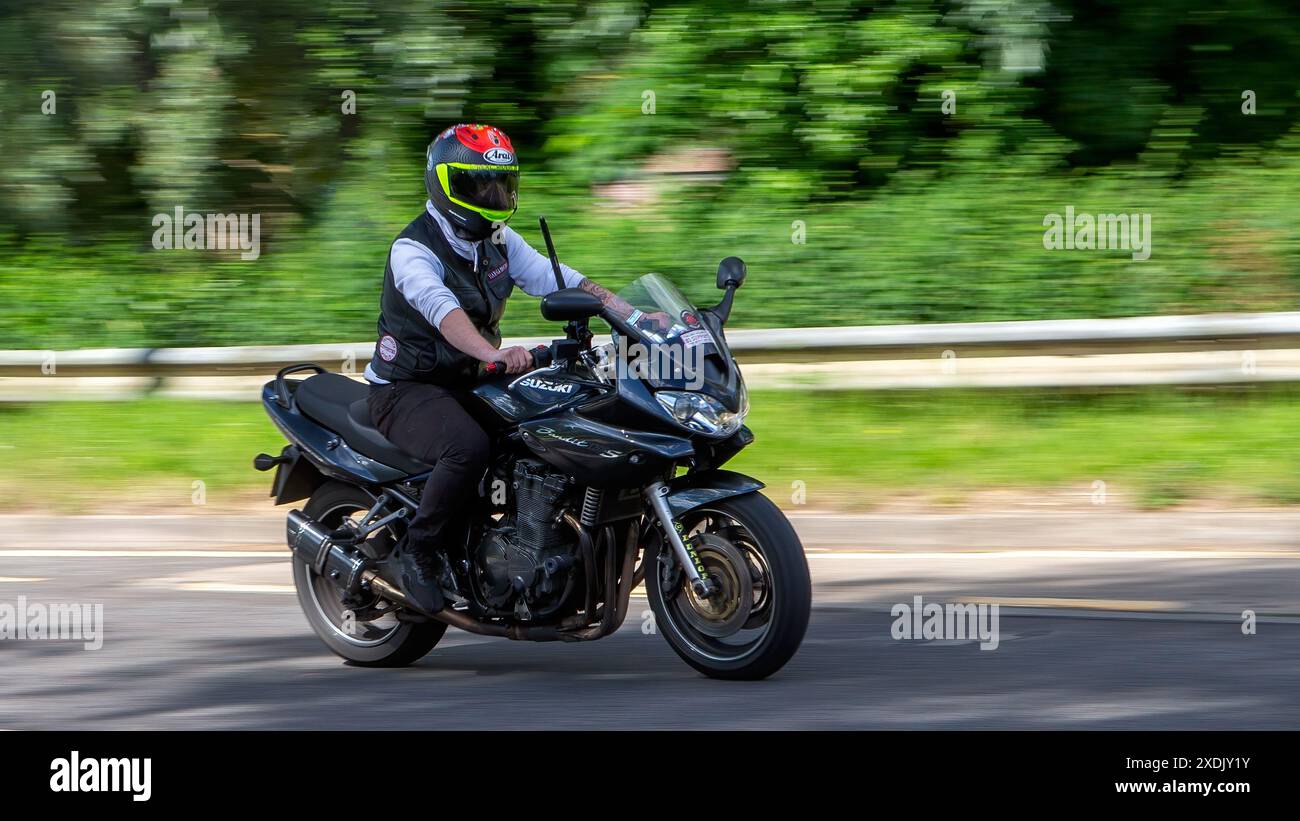 Milton Keynes, Regno Unito - 22 giugno 2024: Uomo in sella a una moto Suzuki Bandit su una strada di campagna britannica Foto Stock