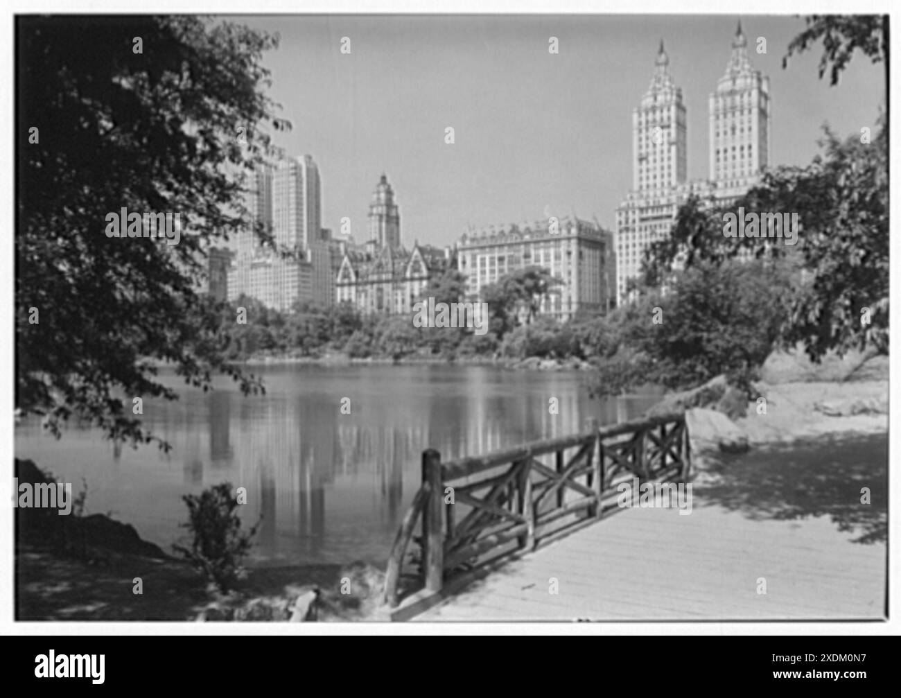 Vista sulla città di New York. Central Park West, riflesso nel lago, ponte in primo piano. Collezione Gottscho-Schleisner Foto Stock