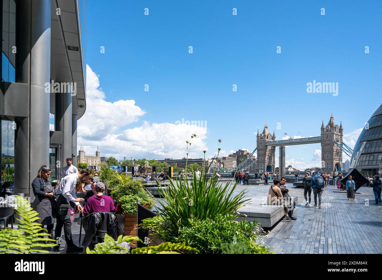 Ristorante e turisti presso il Tower Bridge e il City Hall di Southwark con la Torre di Londra visibile in una giornata di sole a Londra, Inghilterra Foto Stock