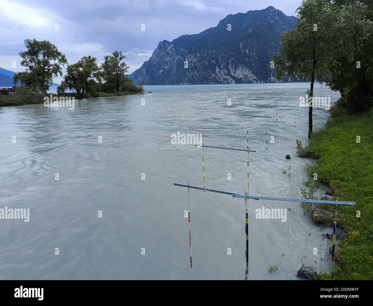 Nago-Torbole, Lago di Garda, Italia - 23 giugno 2024: Volumi d'acqua fluiscono dal fiume Sarca al Lago di Garda, nella località turistica settentrionale di Torbole dopo piogge e tempeste persistenti. Il lago ha un alto livello d'acqua *** Wassermengen fließen im nördlichen Urlaubsort Torbole vom Fluss Sarca nach anhaltenden Regenfällen und Unwetter in den Gardasee. Vedi HAT hohen Pegelstand Foto Stock