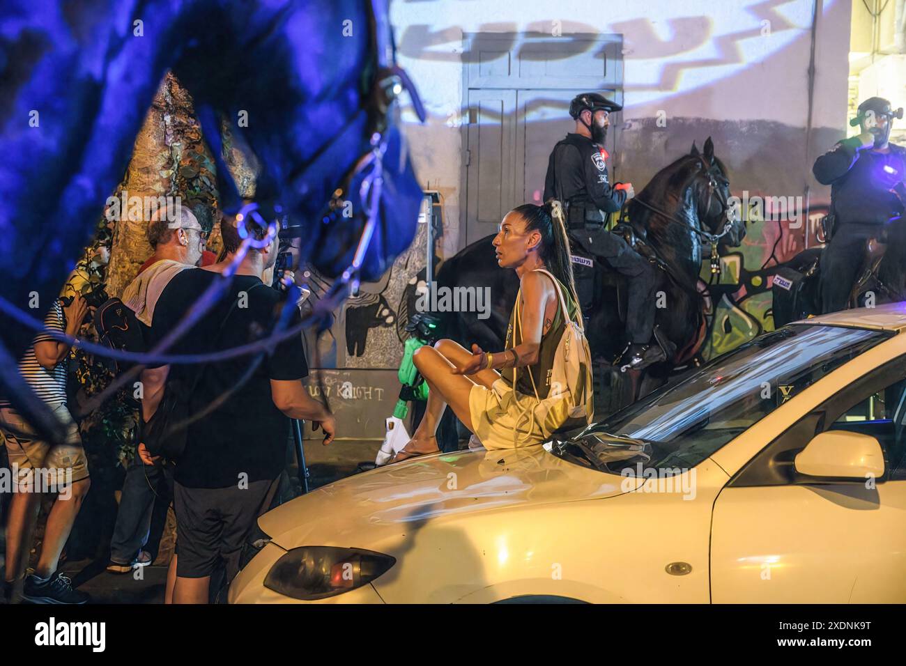 Tel Aviv, Israele. 22 giugno 2024. Un manifestante siede su un'auto mentre gli agenti di polizia israeliani viaggiano sulla strada e marciapiede per disperdere il manifestante dalla strada durante la manifestazione. Oltre 100.000 israeliani hanno manifestato a Kaplan con le famiglie degli ostaggi contro il primo ministro Benjamin Netanyahu, chiedendo un accordo immediato con gli ostaggi e il cessate il fuoco, a seguito della manifestazione i manifestanti avevano allestito un falò di fronte al "Metzudat Ze'ev" - il quartier generale storico del partito del Likud, causando scontri con la polizia israeliana. Credito: SOPA Images Limited/Alamy Live News Foto Stock