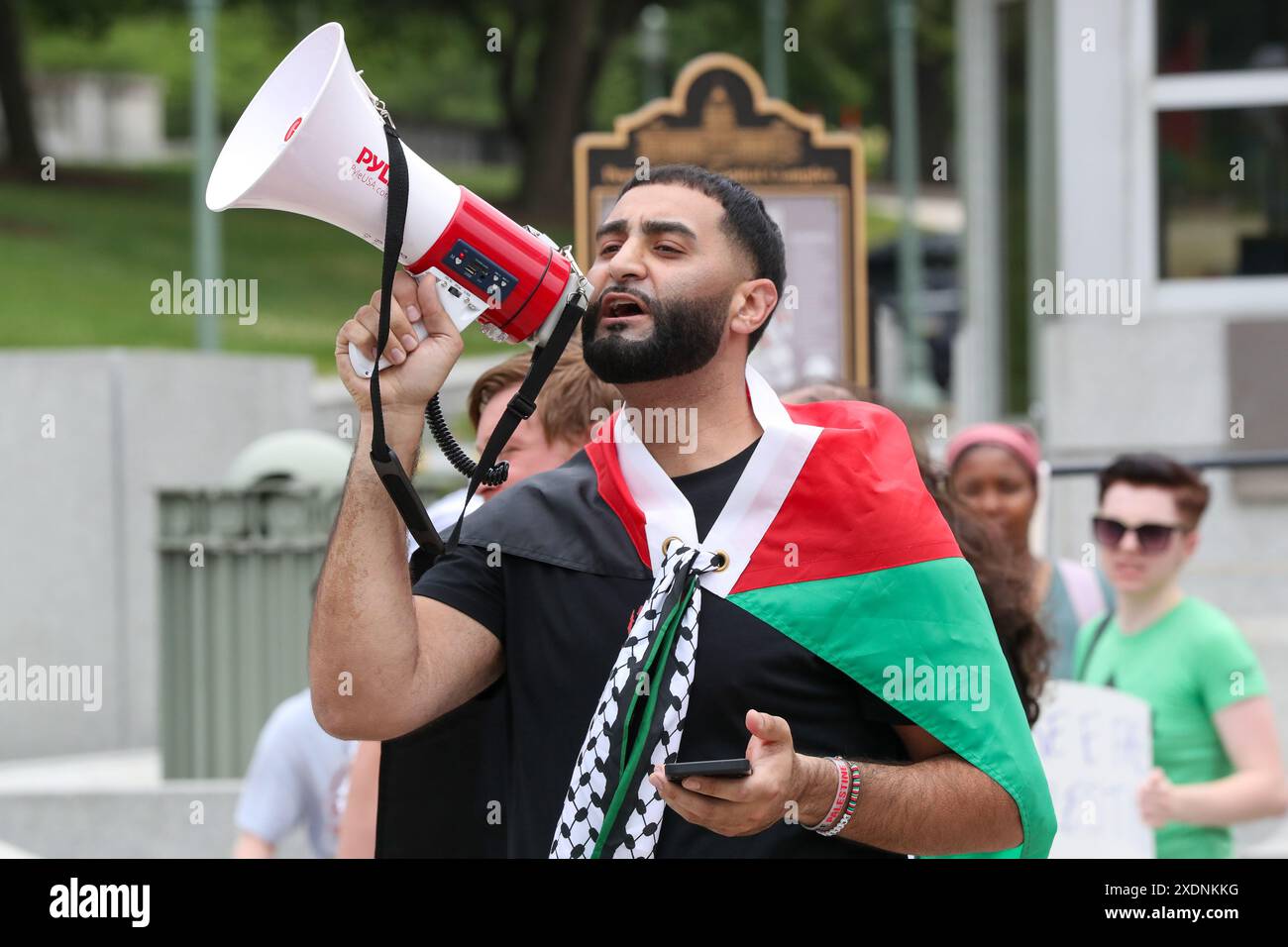 Harrisburg, Stati Uniti. 23 giugno 2024. Un uomo conduce canti durante una manifestazione per la Palestina e il Sudan al Campidoglio della Pennsylvania ad Harrisburg il 23 giugno 2024. La manifestazione è stata organizzata da llah Charity e dalla coalizione palestinese di Harrisburg in riconoscimento del diritto del popolo sudanese e palestinese all'autodeterminazione e all'indipendenza. (Foto di Paul Weaver/Sipa USA) credito: SIPA USA/Alamy Live News Foto Stock