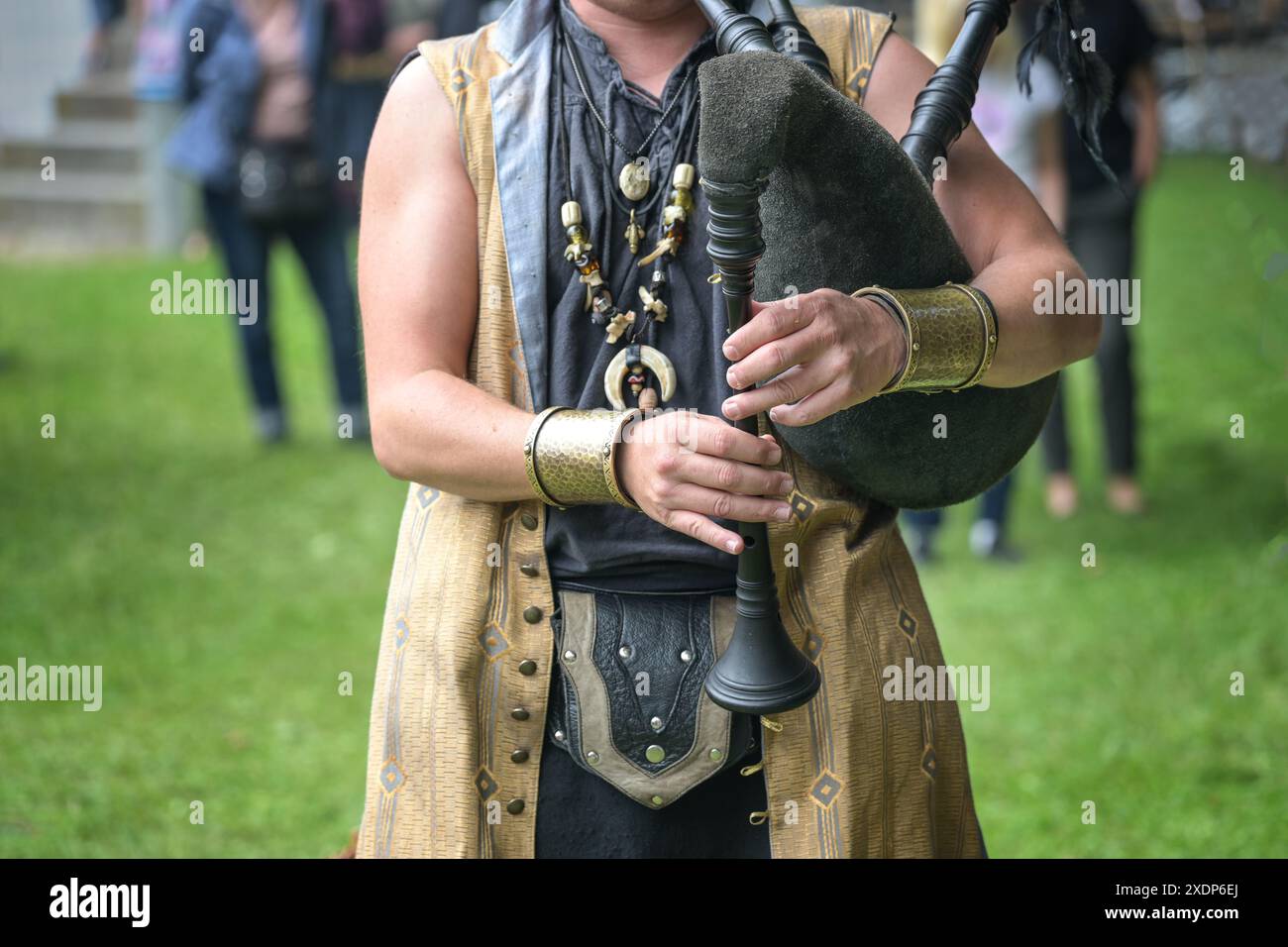 Musicista in costume medievale che suona le cornamuse in pelle e legno, esibizione di musica folk in un evento di festival del Medioevo, spazio copia, selezione Foto Stock