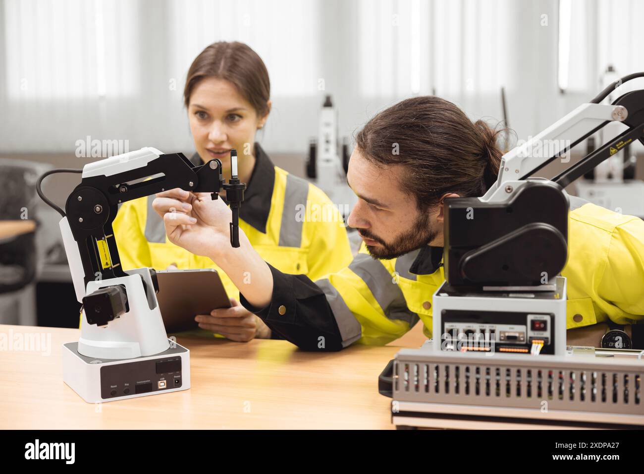 Programma di robotica industriale studenti universitari che imparano l'assemblaggio meccanico con robot Universal Training Platform mod di simulazione braccio robotico Foto Stock