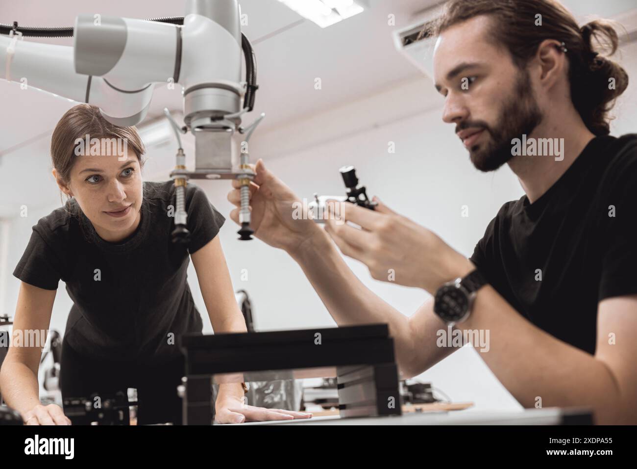 Programma di robotica industriale studenti universitari che imparano l'assemblaggio meccanico con robot Universal Training Platform mod di simulazione braccio robotico Foto Stock