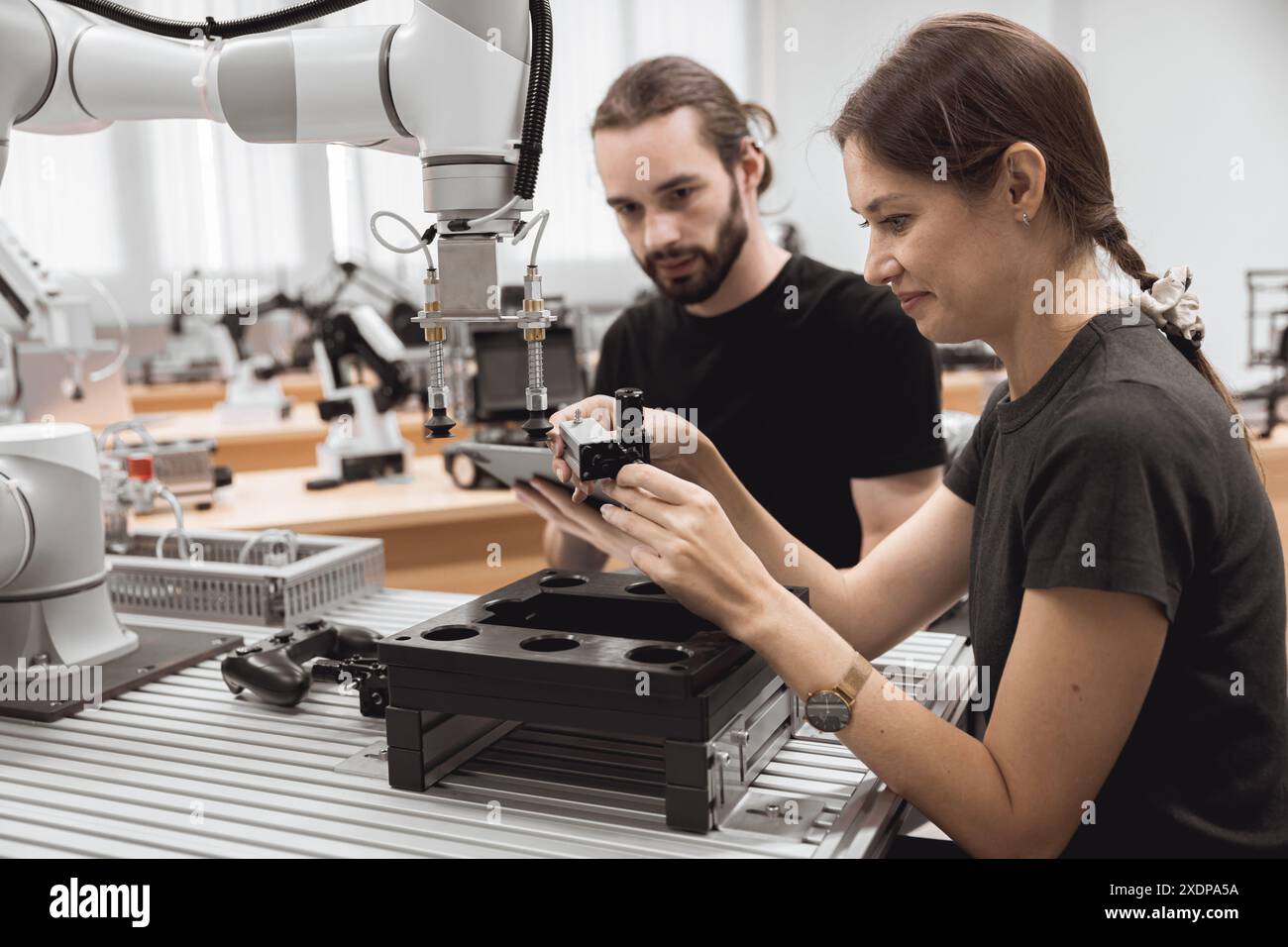 Programma di robotica industriale studenti universitari che imparano l'assemblaggio meccanico con robot Universal Training Platform mod di simulazione braccio robotico Foto Stock