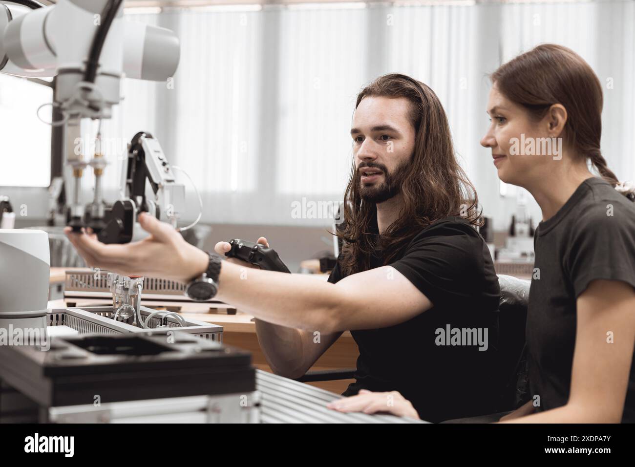 Programma di robotica industriale studenti universitari che imparano l'assemblaggio meccanico con robot Universal Training Platform mod di simulazione braccio robotico Foto Stock