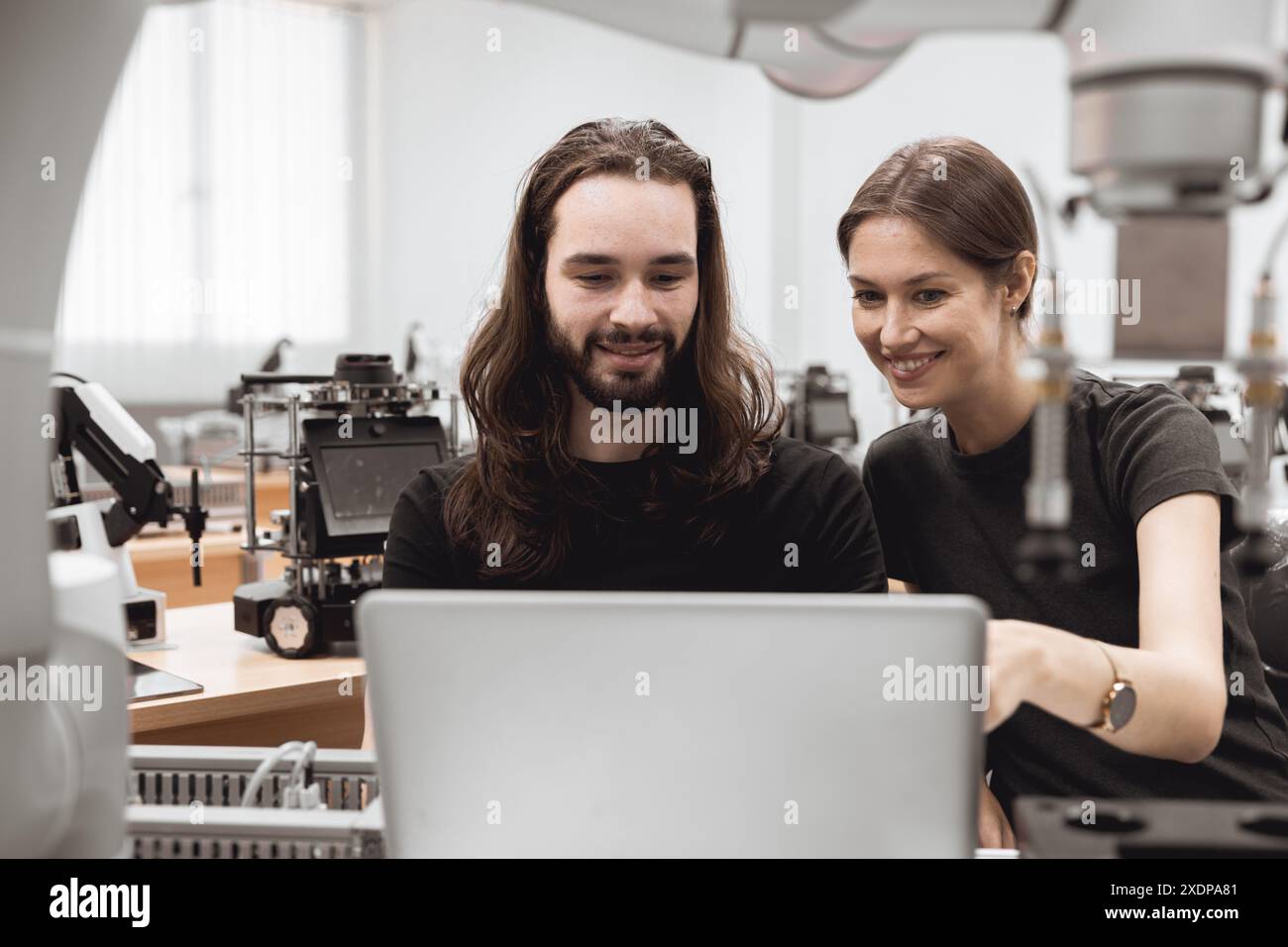 Team di ingegneri studente universitario imparare controllare operare e programmare il braccio robotico industriale con computer portatile in aula di laboratorio di ingegneri robotici in poli Foto Stock