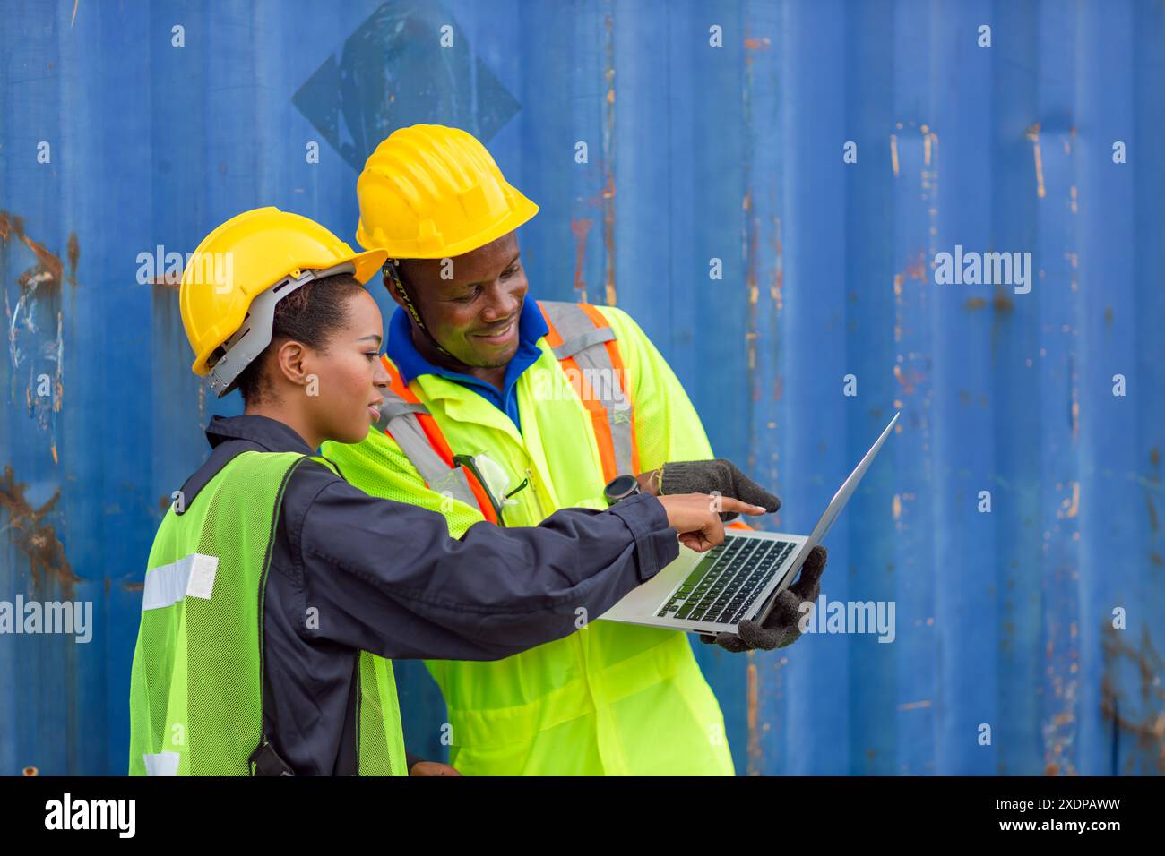 African Black Worker Teamwork in Cargo Port Shipping Industrial in Yellow Hard Hat Safety Vest On Duty. Caposquadra o supervisore nel cantiere di spedizione container T. Foto Stock