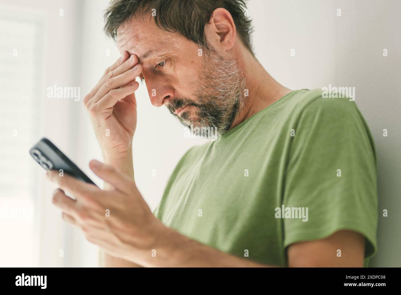 Man ha ricevuto messaggi di testo o e-mail preoccupanti sullo smartphone, attenzione selettiva Foto Stock