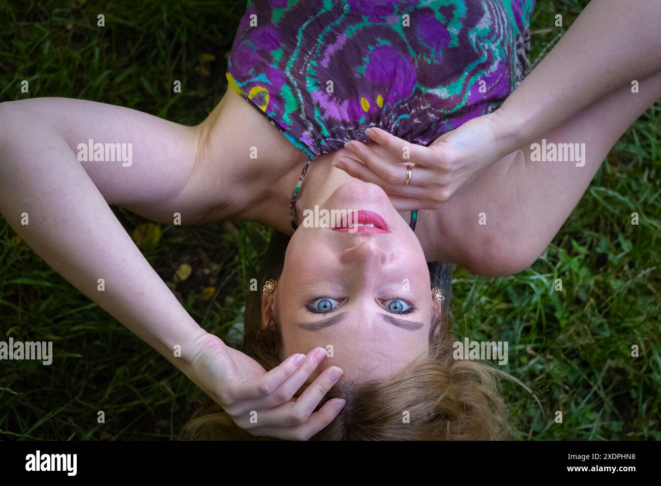 Donna stesa per terra con le mani sul viso Foto Stock