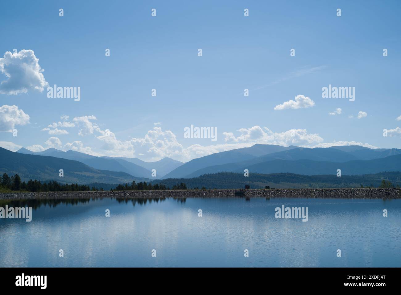 Lago Dillion sotto un cielo luminoso con riflessi di montagne. Foto Stock