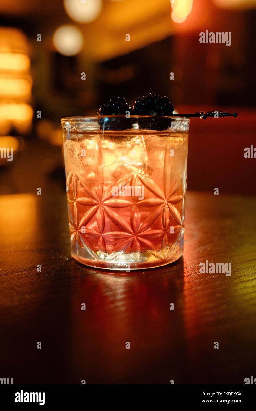 Cocktail in un bicchiere di cristallo con guarnigione di mora Foto Stock
