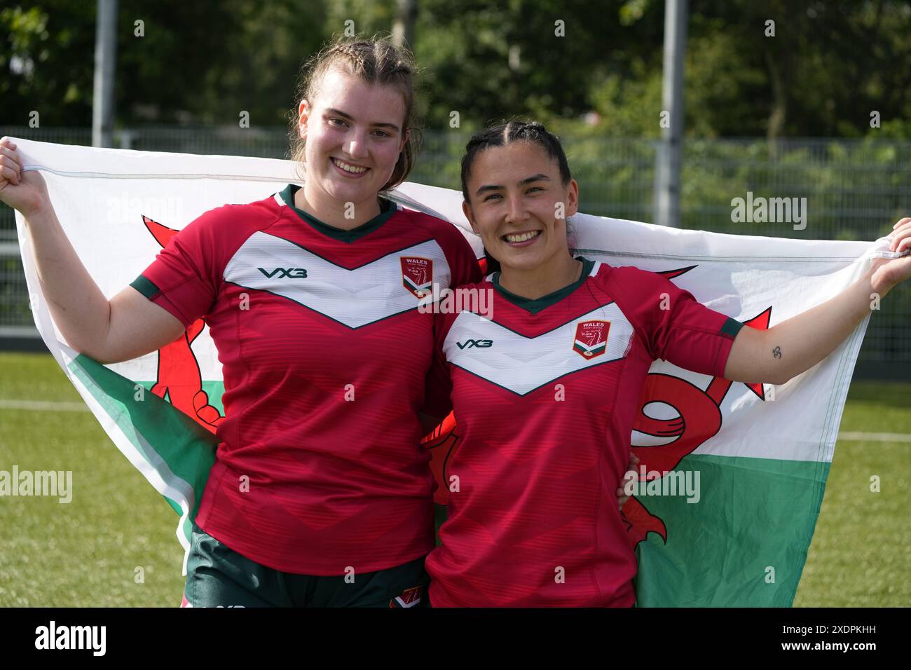 I debuttanti Gracie Hobbs (L) e Megan Whittaker festeggiano con una bandiera gallese dopo la vittoria del Galles sul rugby a 13 olandese Foto Stock