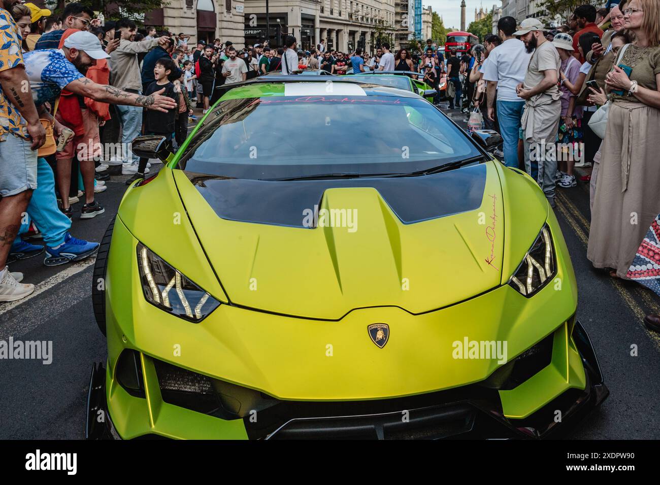 Una supercar verde lime affiancata dai fan nella Piccadilly di Londra. Foto Stock