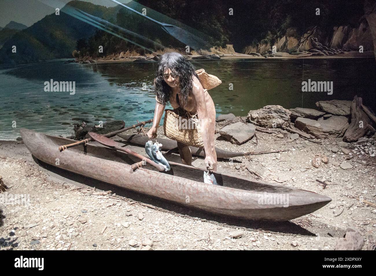 Un diorama della vita maori al museo di Canterbury che mostra una donna con una canoa. Immagine sgranata ottenuta con la luce disponibile. Foto Stock