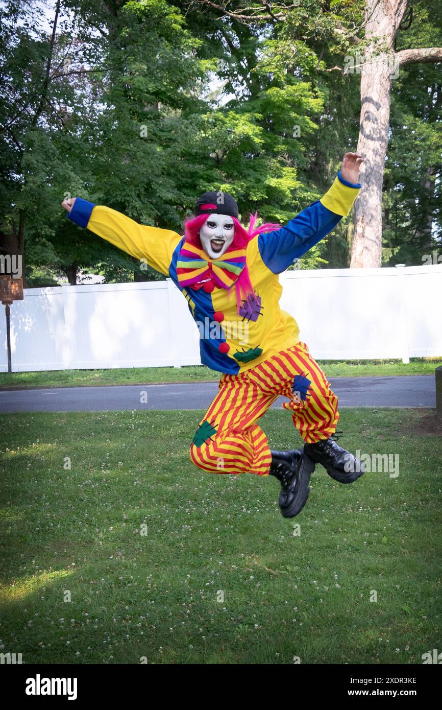 Un artista di drag performance in costume da clown che fa un calcio di campana prima della Pride Parade & Fair a Red Hook, New York. Foto Stock