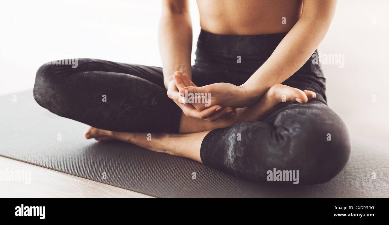 Donna flessibile pratica posa yoga avanzata su tappetino, corta Foto Stock