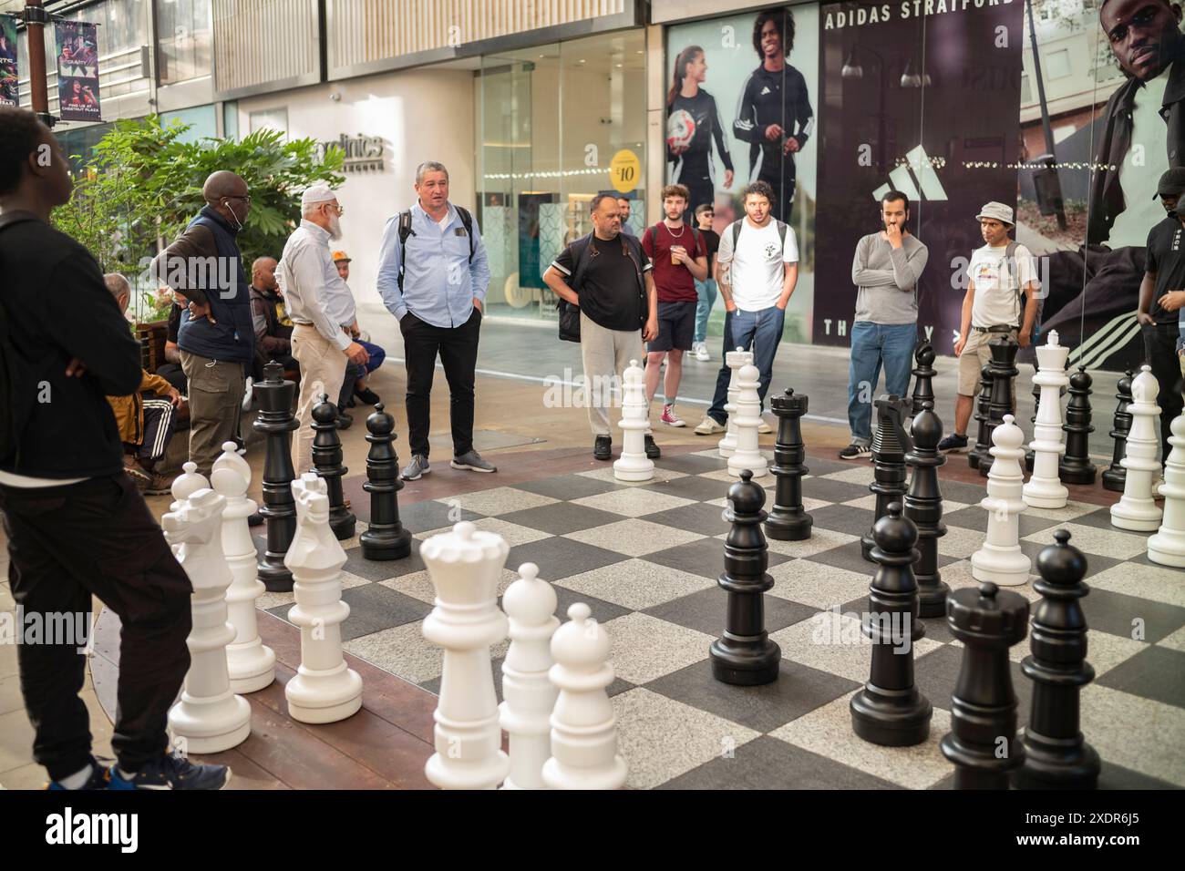 Uomini che giocano a scacchi giganti all'interno del centro commerciale Westfield, Stratford, East London, Inghilterra, Regno Unito Foto Stock