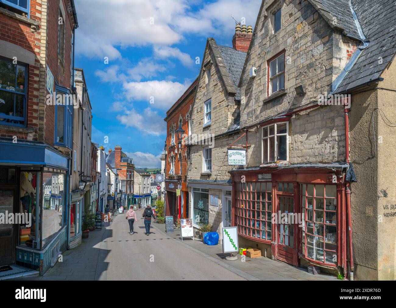 Negozi e caffetterie sulla High Street nel centro della città, Stroud, Gloucestershire, Inghilterra, Regno Unito Foto Stock