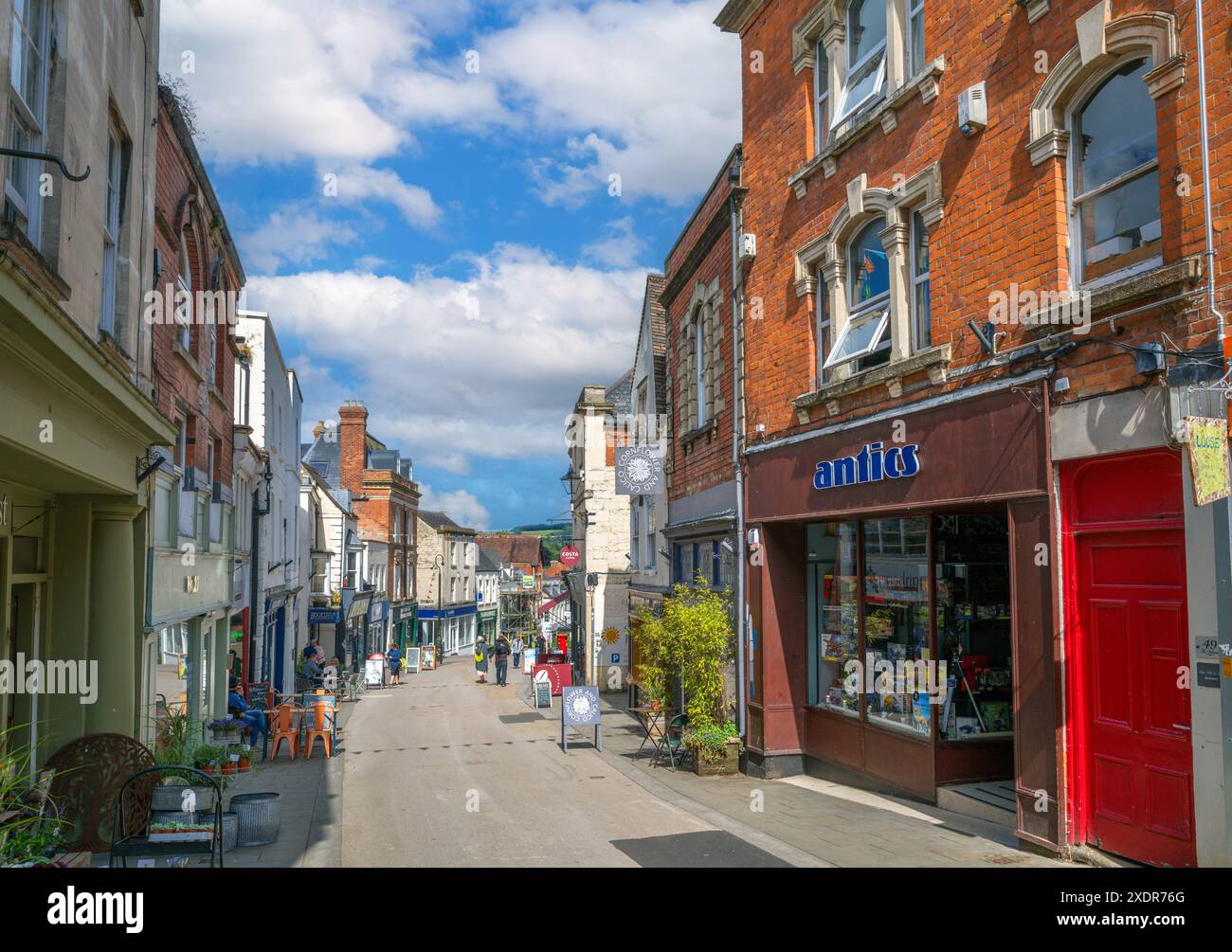 Negozi e caffetterie sulla High Street nel centro della città, Stroud, Gloucestershire, Inghilterra, Regno Unito Foto Stock