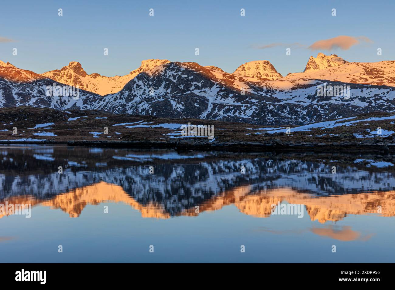 Riflesso delle montagne in un fiordo al tramonto, alla luce della sera, in inverno, Moskenesoya, Lofoten, Norvegia, Europa Foto Stock