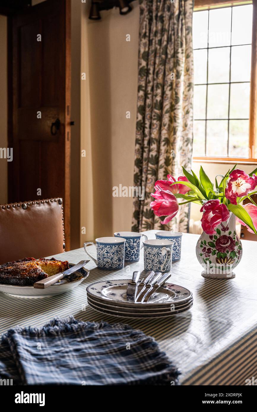 Tulipani e piatti laterali con torta in cucina della fattoria Tudor del XVI secolo, Hertfordshire, Inghilterra, Regno Unito. Foto Stock