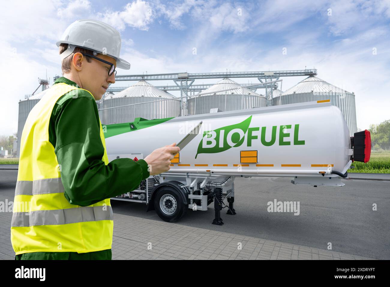 Uomo con tablet digitale sullo sfondo di un rimorchio con biocarburante. Foto Stock